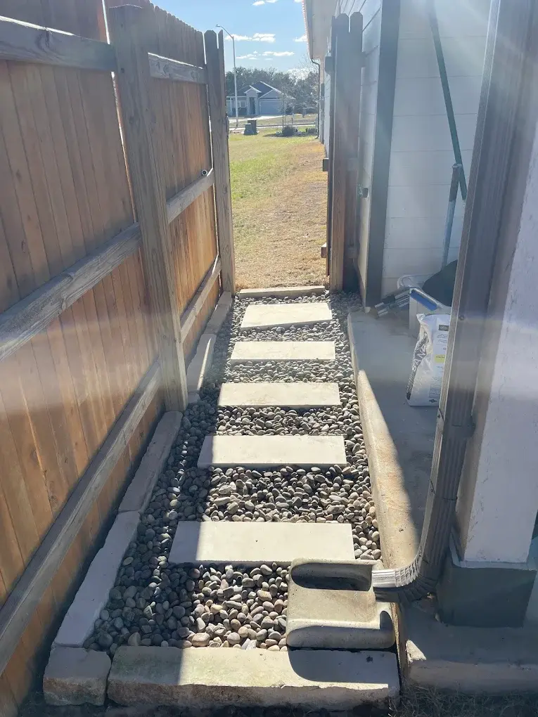 Stone pathway flanked by custom welded fencing on a Burnet property