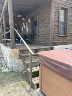 Hill Country log cabin and surrounding tree line maintained by VP Welding