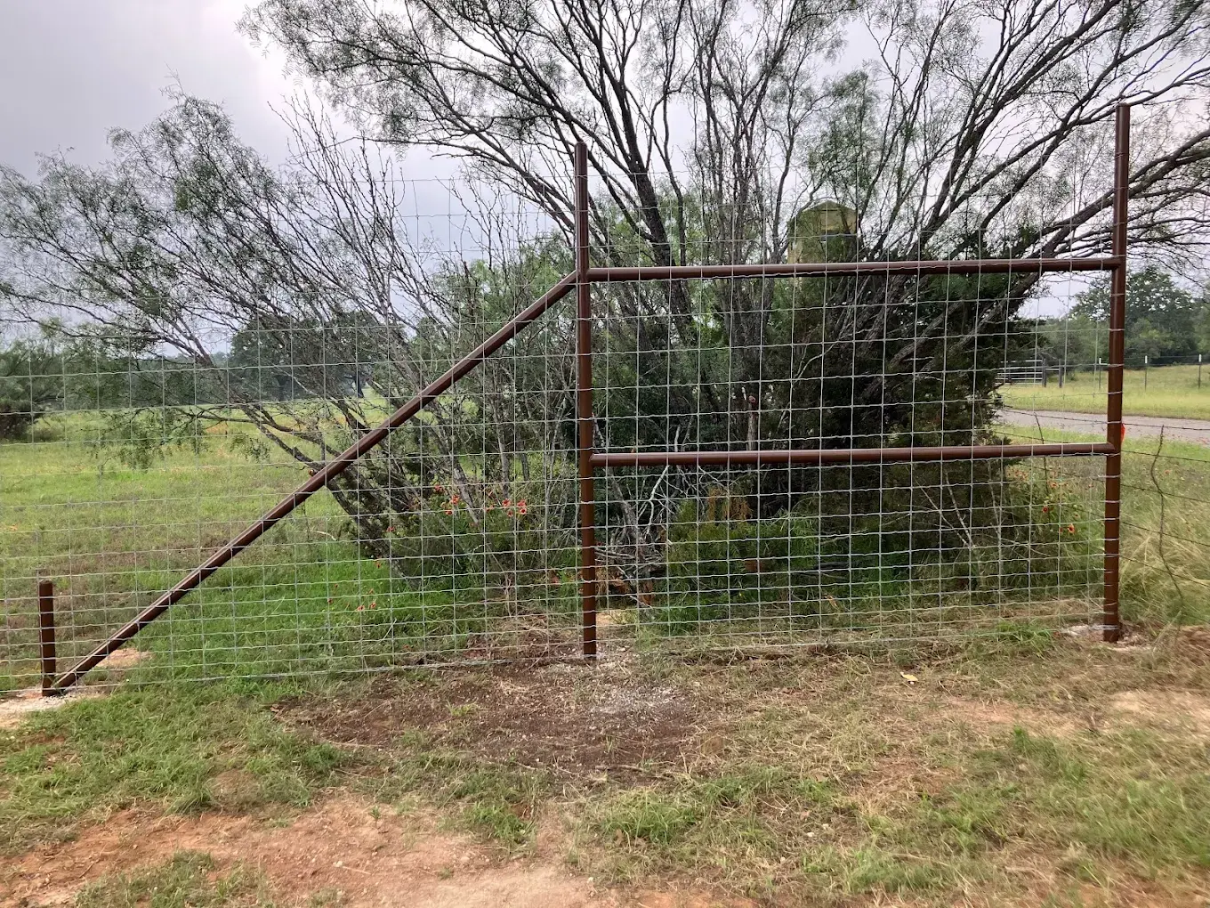 Welded metal fence panels installed along the perimeter of a Burnet County property